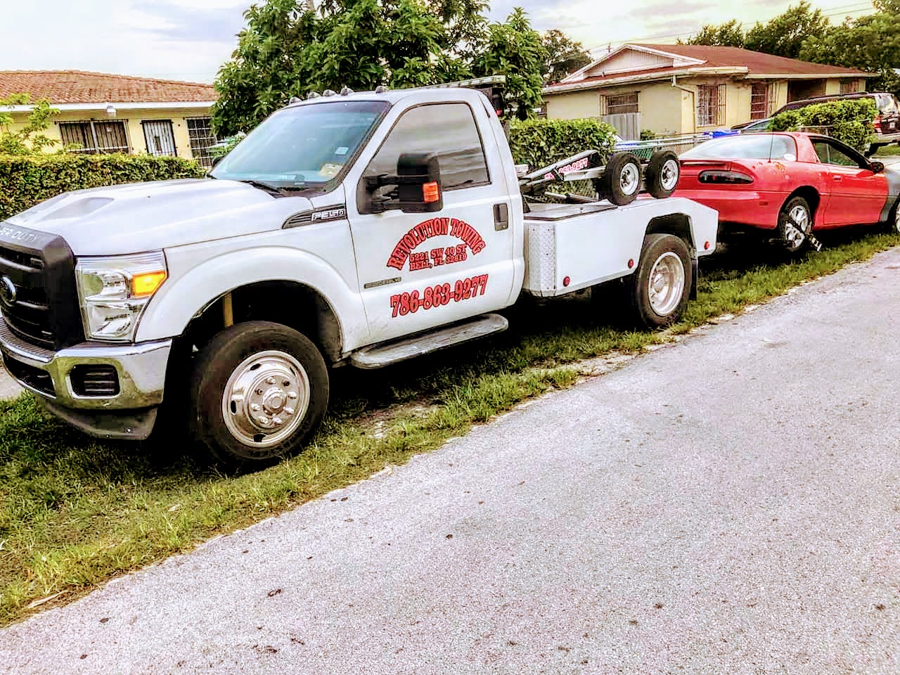 Revolution Towing flatbed truck loading a vehicle in Miami